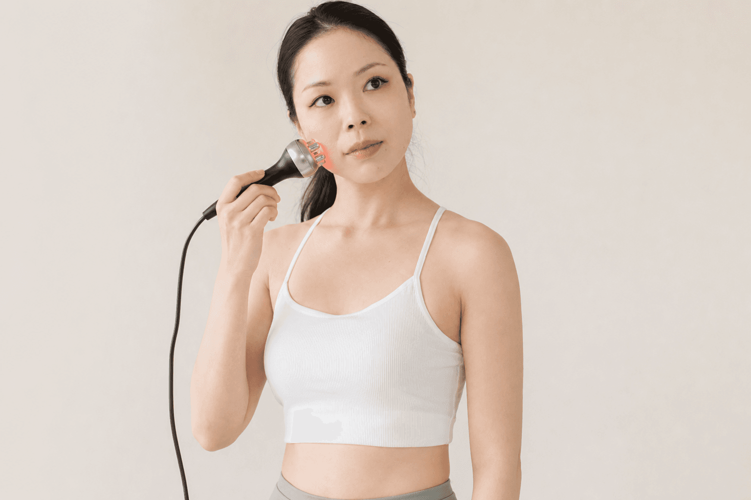 Lithe スタジオ内 — フェイシャルセルフエステ機器でケアを行う様子